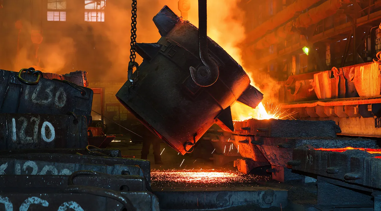 Ladle pouring molten metal beside chalk-numbered moulds