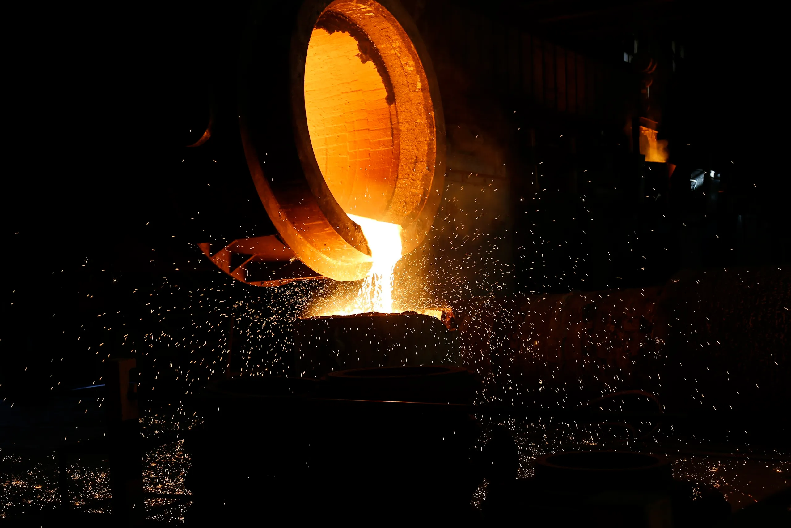 Molten metal tapped from a rotary furnace into a crucible